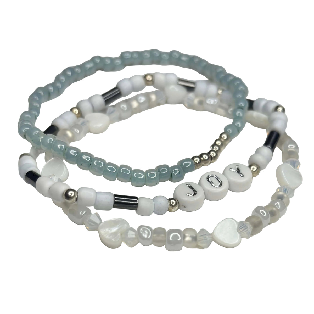 Close-up of Joy bracelet stack featuring blue and white beads, silver accents, hematite details and shell hearts.